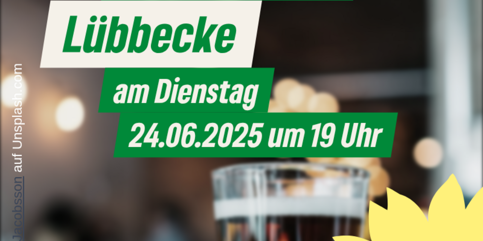 Im Hintergrund verschwommen ein Bistro im Vordergrund ein gefülltes Bierglas. Text: Grüner Stammtisch Lübbecke mit dem aktuellen Datum und Uhrzeit 19:00 Uhr