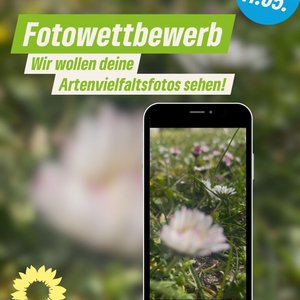 ein Handy mit dem Bild einer Blumenwiese im Display. Dazu der Text "Fotowettbewerb Wir wollen deine Artenvielfaltfotos sehen. Einsendeschluss 11.05.